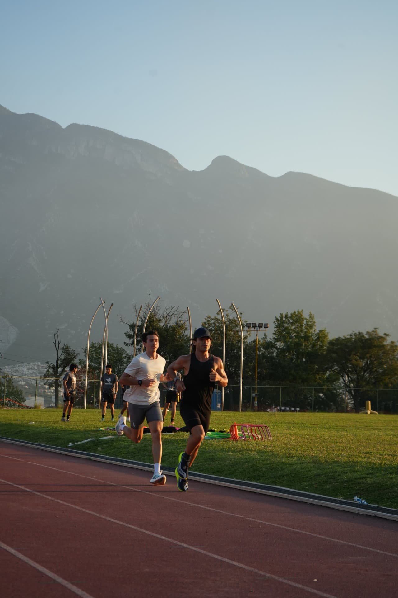 Atletas entrenando juntos en una pista al aire libre
